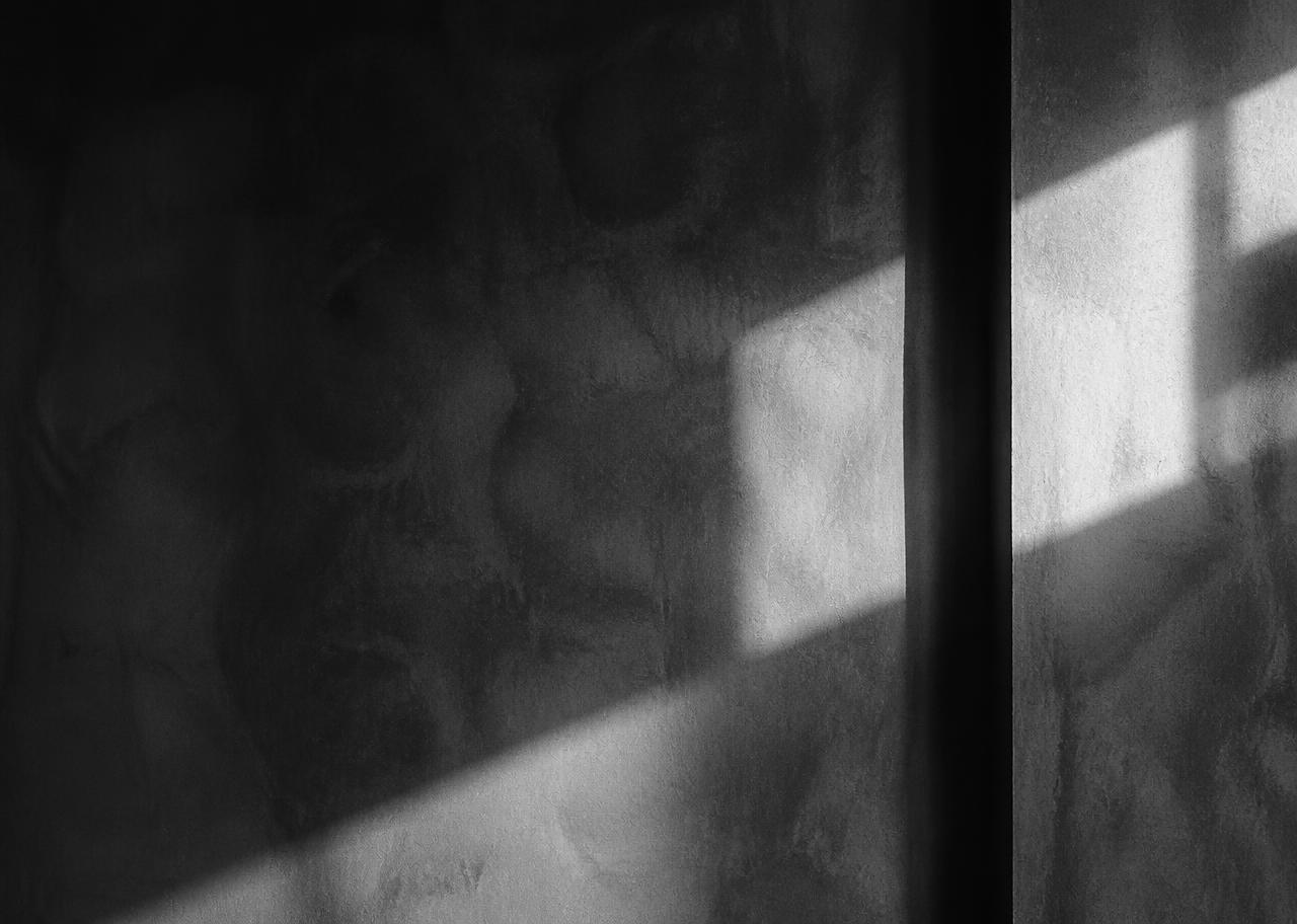 Abstract light and shadow across a raw wall, placeholder for future storefront photography